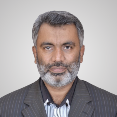 Professional headshot of a middle-aged man with gray hair and beard.