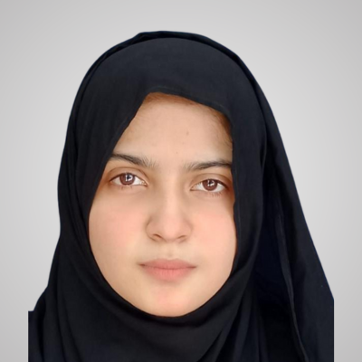 Portrait of a young woman wearing a black hijab against a plain background.